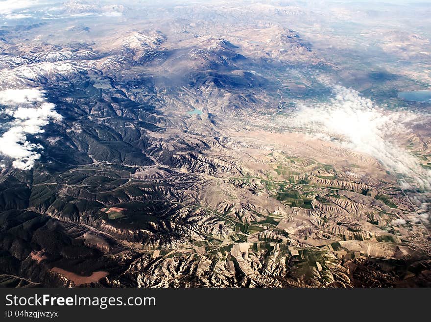 View of the mountains from an airplane above the clouds. View of the mountains from an airplane above the clouds