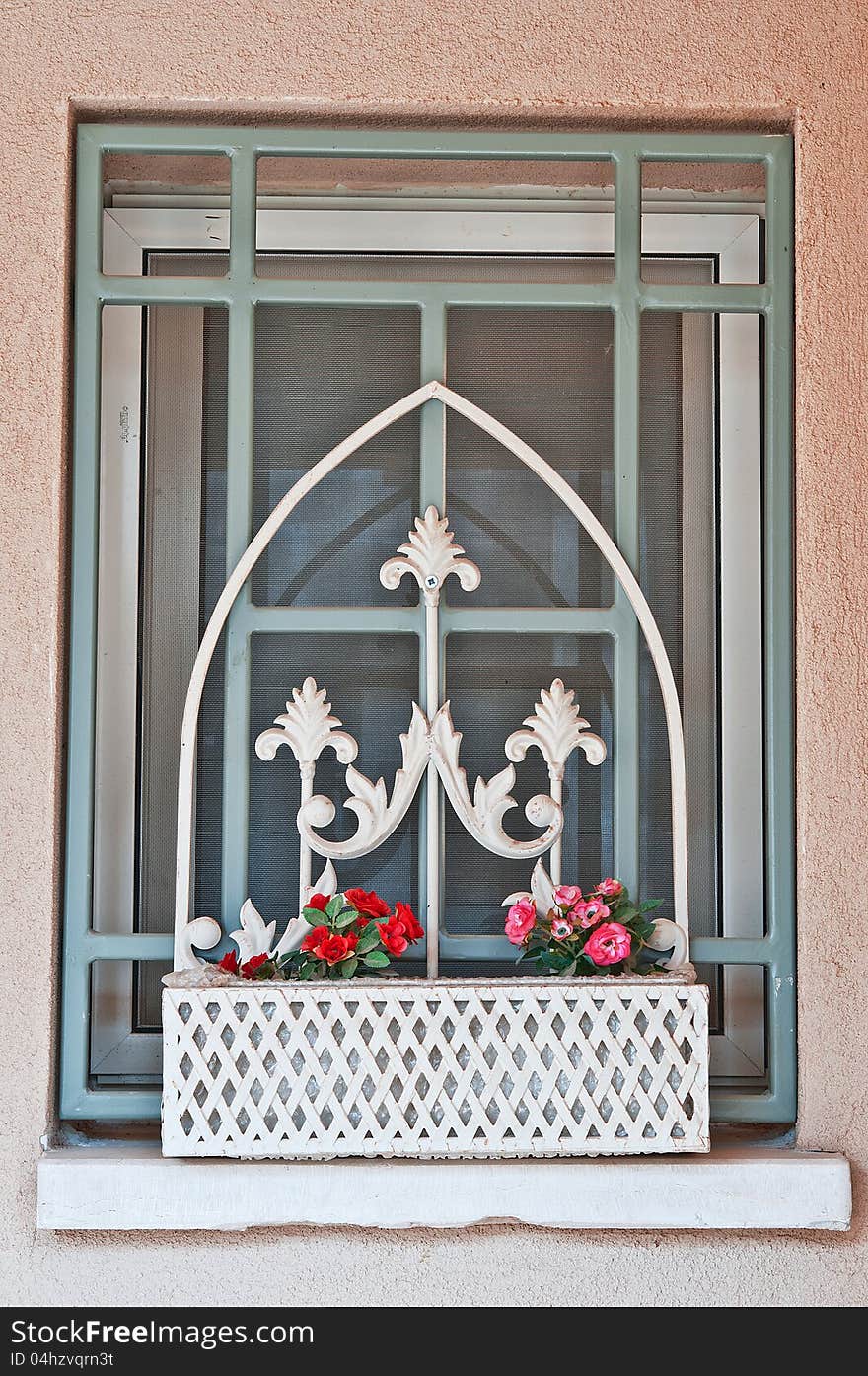 Window with bars in the country house and a decorative box with flowers. Window with bars in the country house and a decorative box with flowers