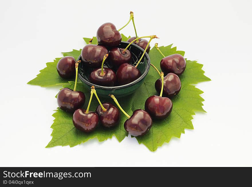 Cherries on a leaf  isolated over white background. Cherries on a leaf  isolated over white background