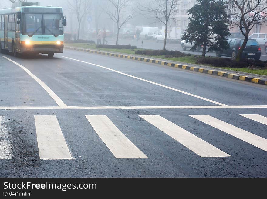 Crosswalk on a city street and trolley approaching. Crosswalk on a city street and trolley approaching