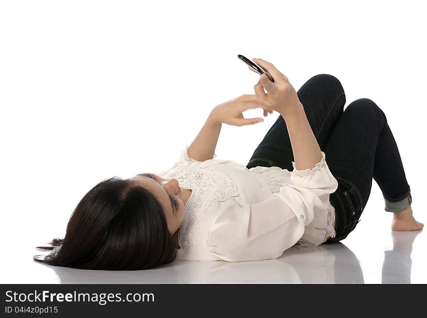 Asian woman texting while laying on the floor. Asian woman texting while laying on the floor