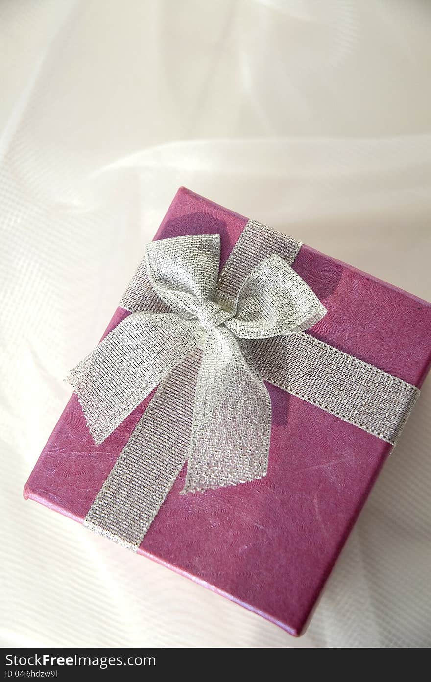 Top view of pink gift box with silver ribbon