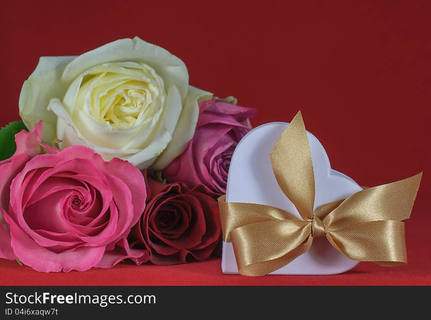 Heart shaped gift box with rose on red background