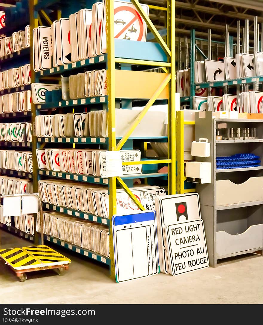 Public street road signs in storage on racks awaiting deployment.