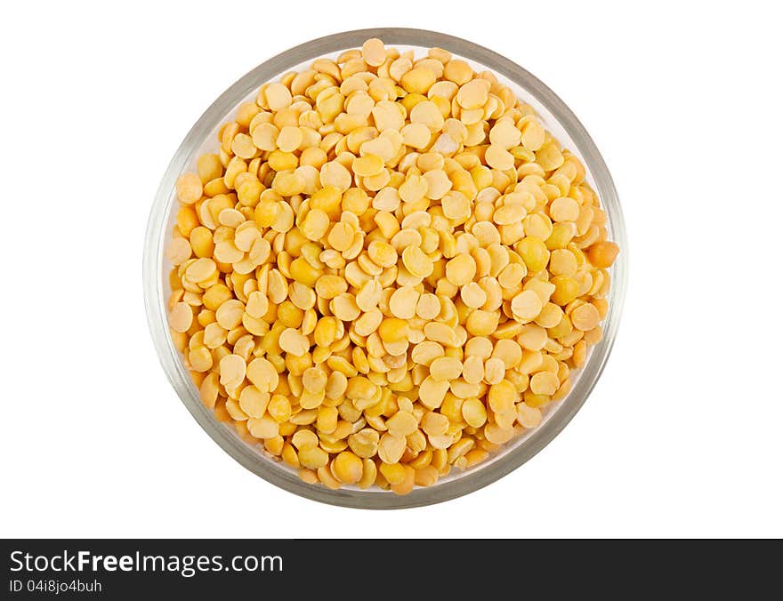 Yellow split peas in transparent glass bowl  over white