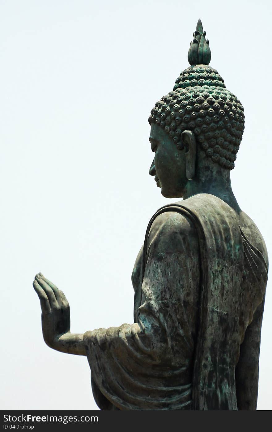 Side view of a statue of blessing Buddha. Isolated on a white background.