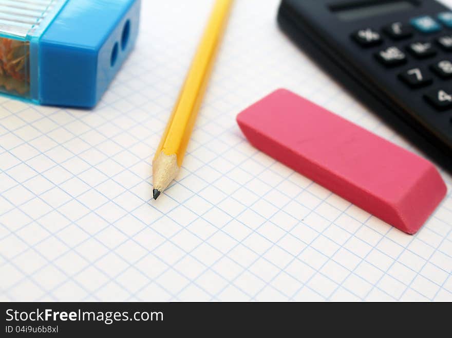 Calculator, pencil and paper clips over white piece of paper. Calculator, pencil and paper clips over white piece of paper