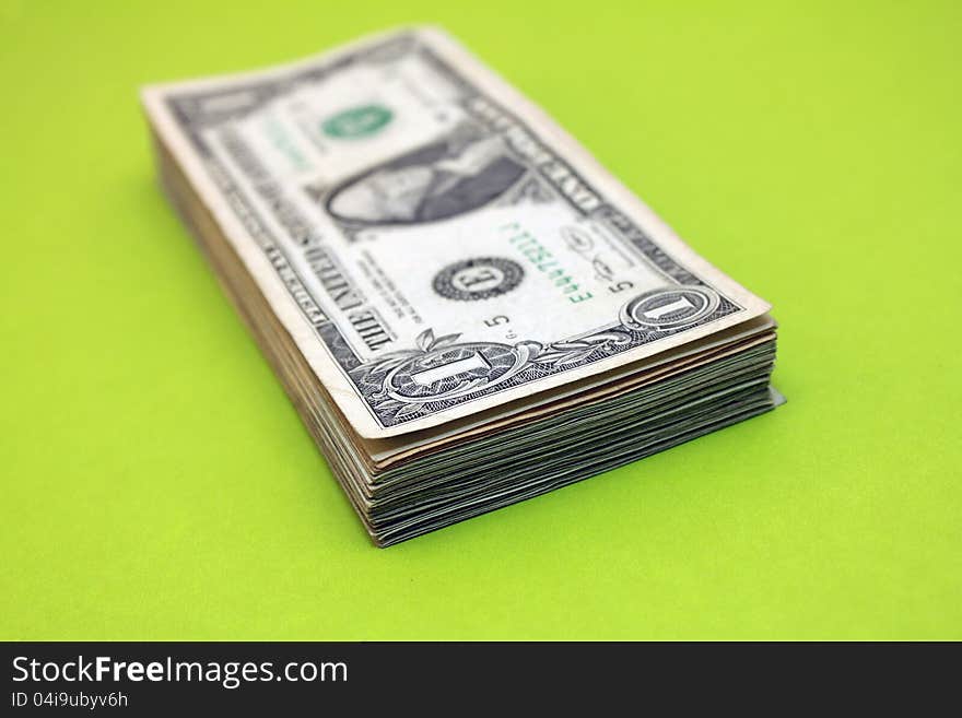 Stack of $1 bills over green background. Stack of $1 bills over green background