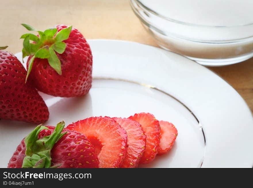 Whole and sliced ripe strawberries on a white plate. Whole and sliced ripe strawberries on a white plate