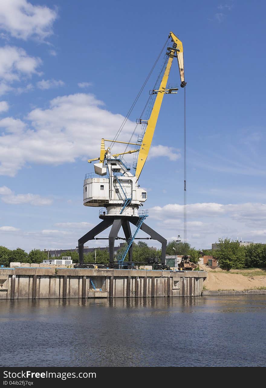 The old port crane on a river mooring. The old port crane on a river mooring.