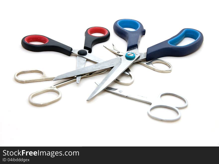 Different set of shears on one meeting, scissors isolated on white background