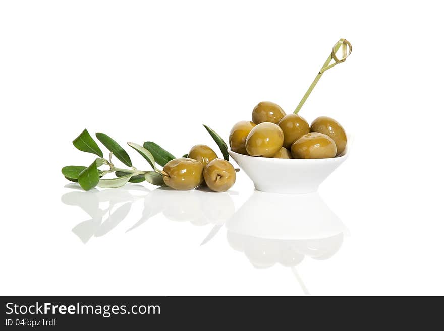 Delicious green olives with fresh branch on white background. Culinary tapas eating. Delicious green olives with fresh branch on white background. Culinary tapas eating.