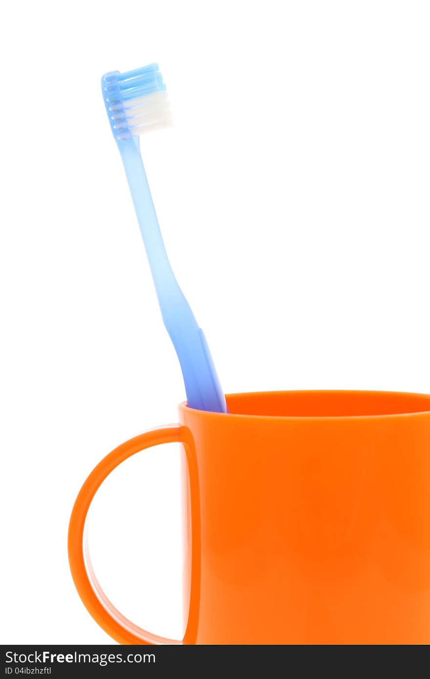 Blue toothbrush and cup on white background