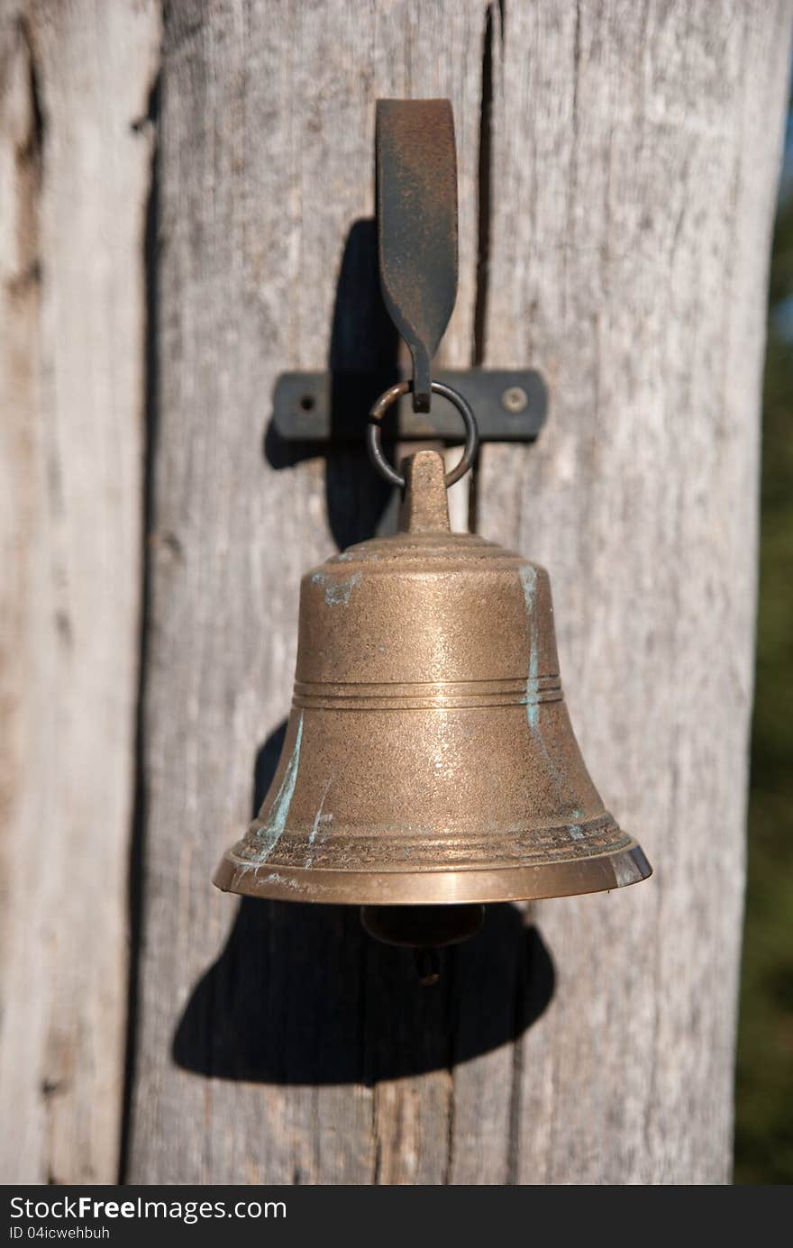 Outdoor brass doorbel on vooden pillar of the gate. Outdoor brass doorbel on vooden pillar of the gate