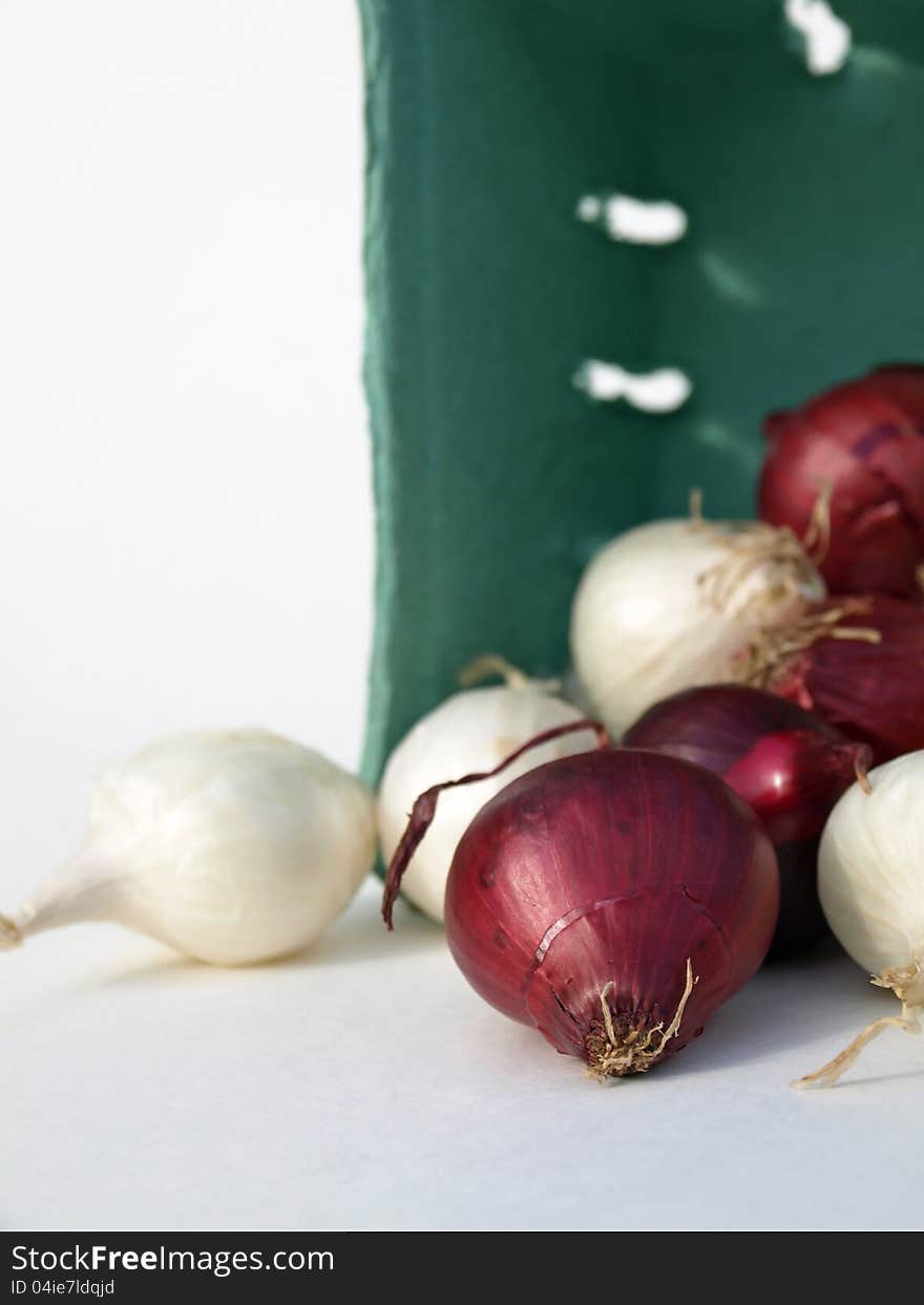 Red and white onions spilling out of container