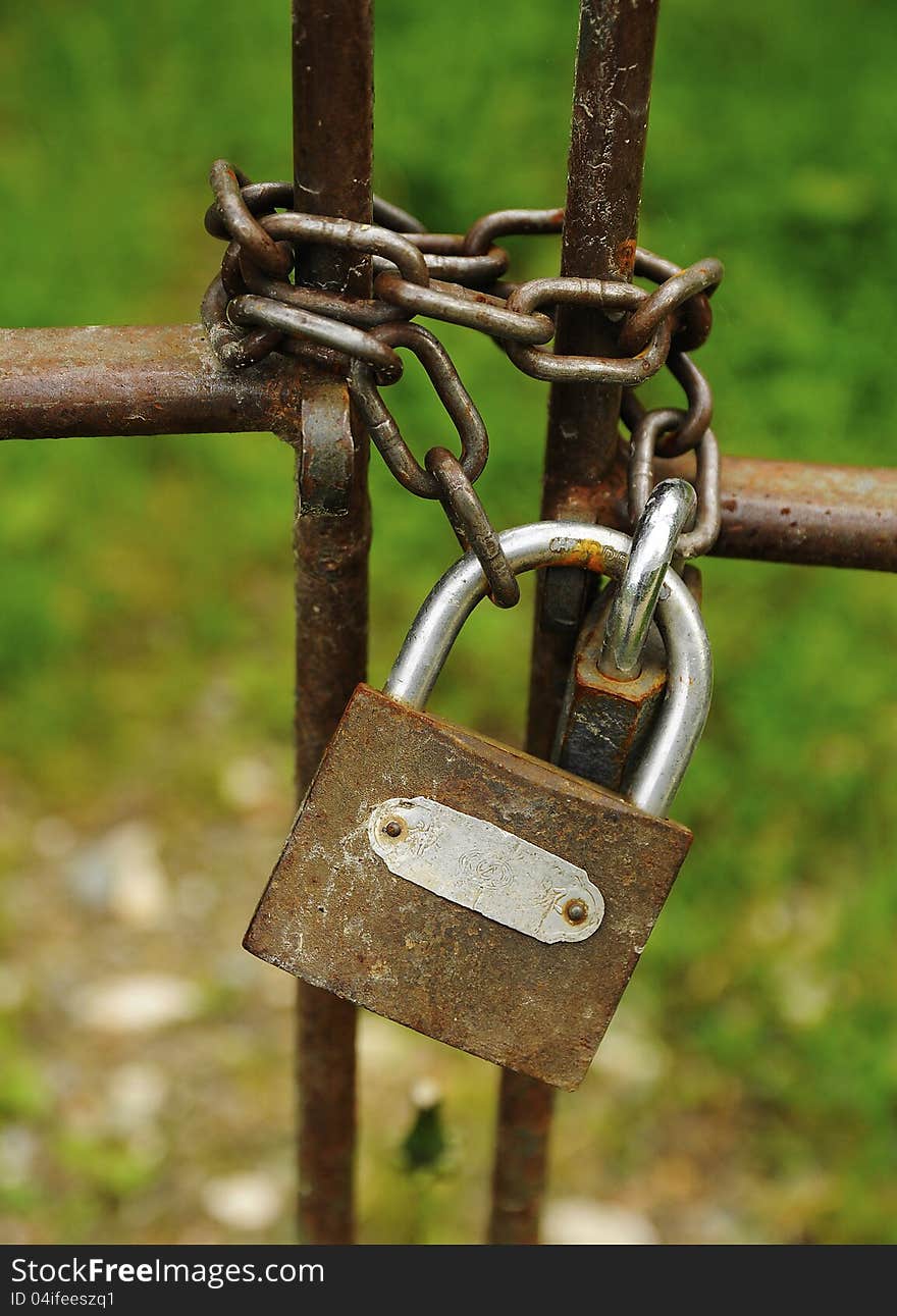 Old rusty lock on a metal gate