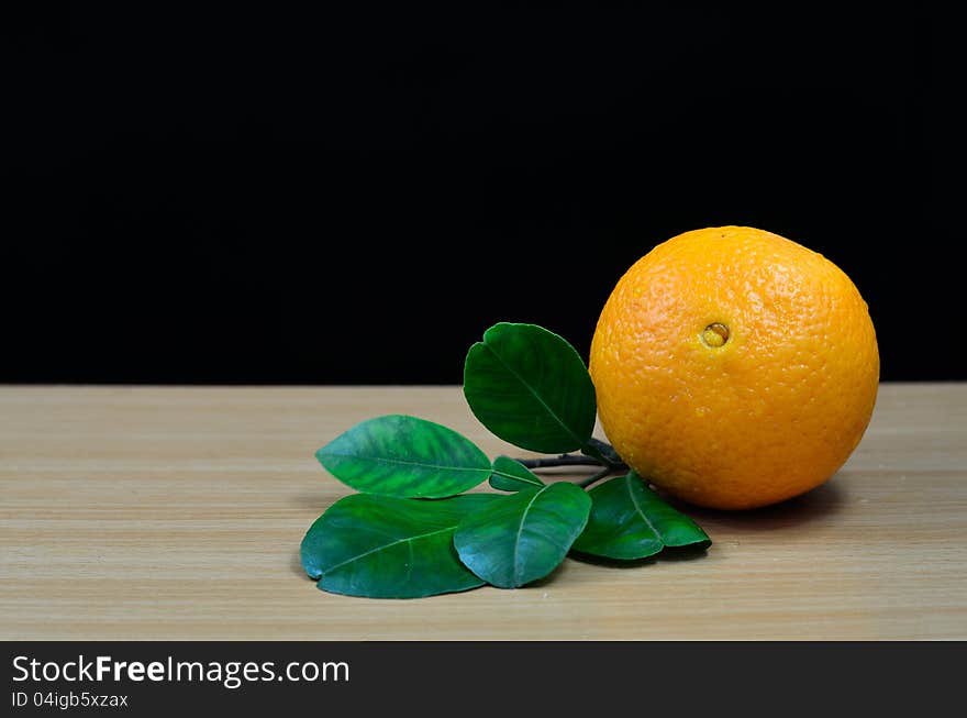 Orange on table with black background