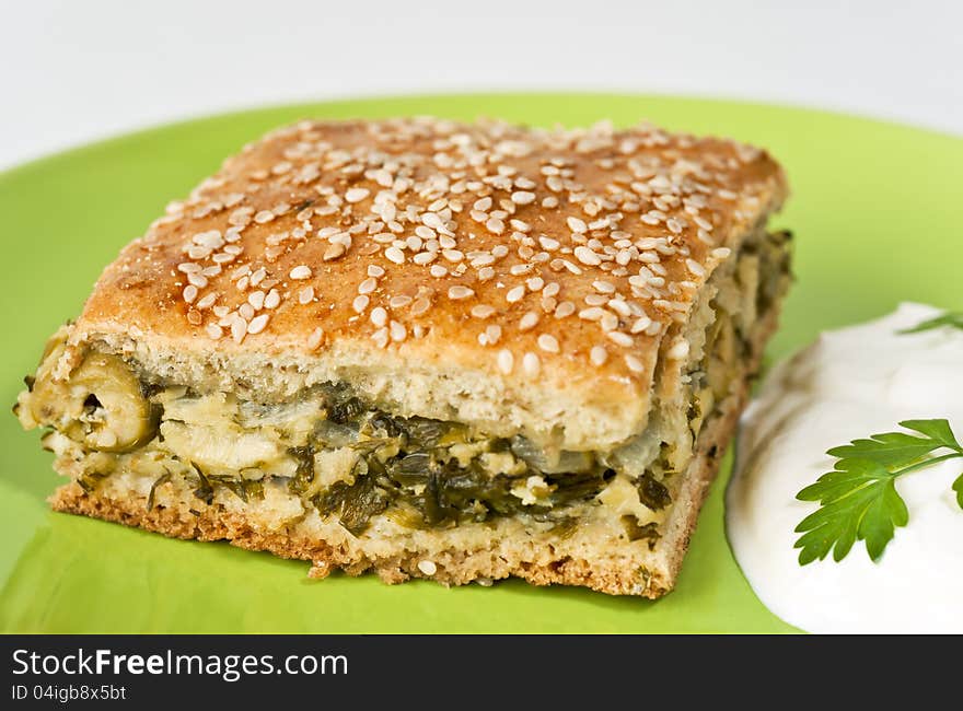 Aromatic green's pie filling spinach and olives on the plate with sour cream. Aromatic green's pie filling spinach and olives on the plate with sour cream