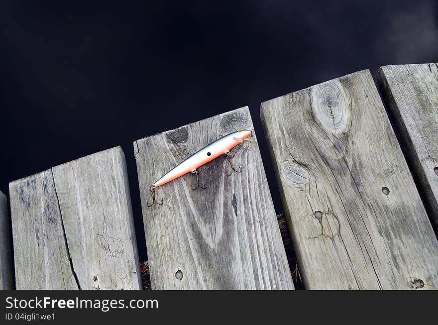 Fishing lure with three hooks, green and orange. Fishing lure with three hooks, green and orange.