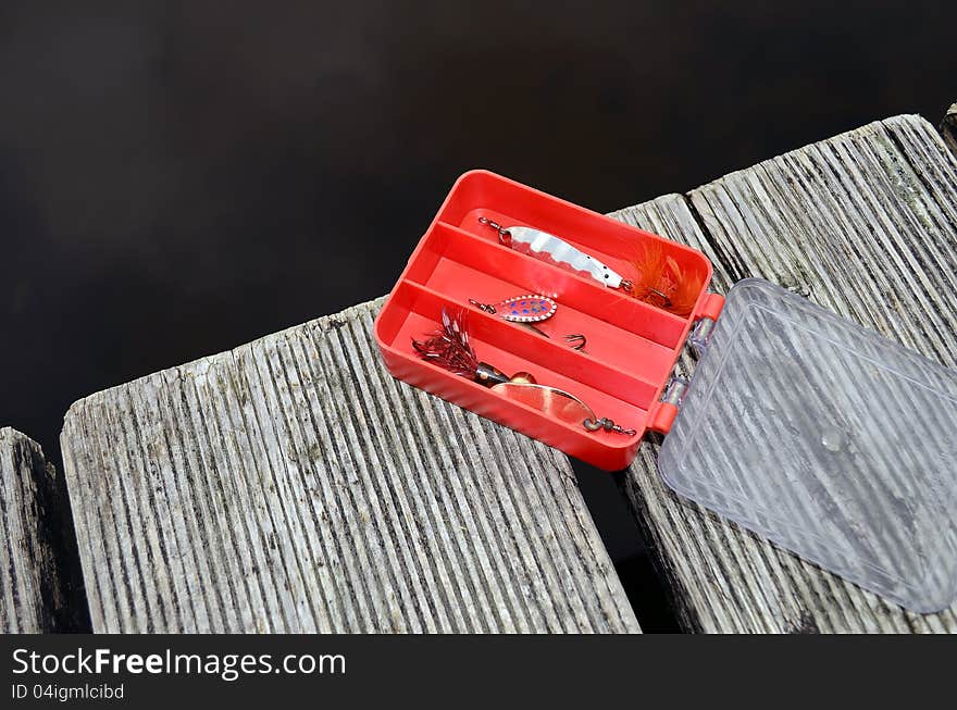 A fishing  Box on a bridge by the lake. A fishing  Box on a bridge by the lake