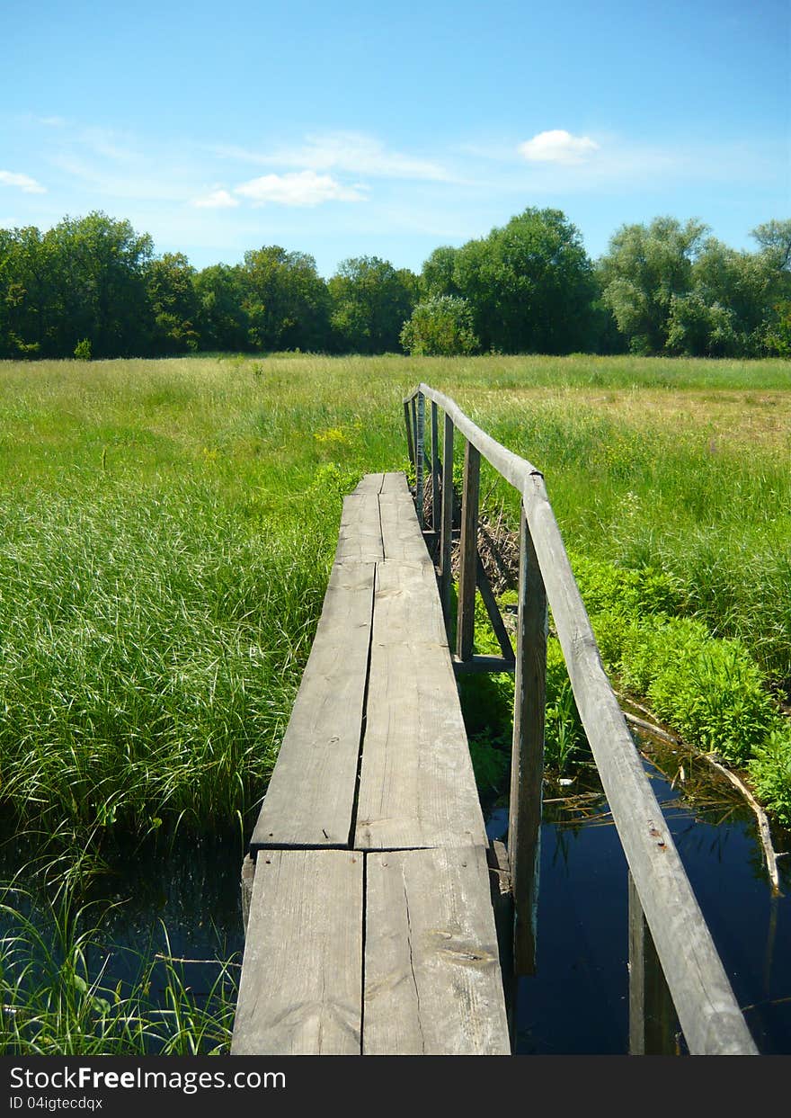 A wooden bridge over a  creek. A wooden bridge over a  creek