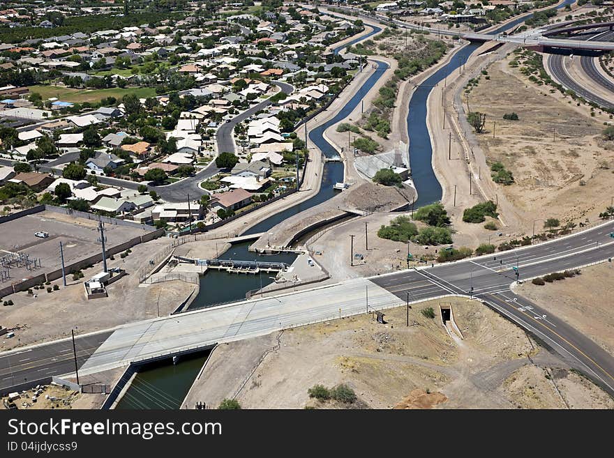 Irrigation canal cutting through suburban desert neighborhood