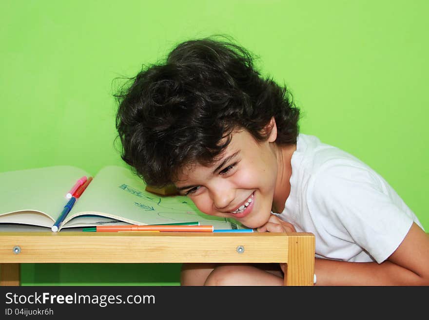 Little boy with curly hair enjoying his drawing at home. Little boy with curly hair enjoying his drawing at home