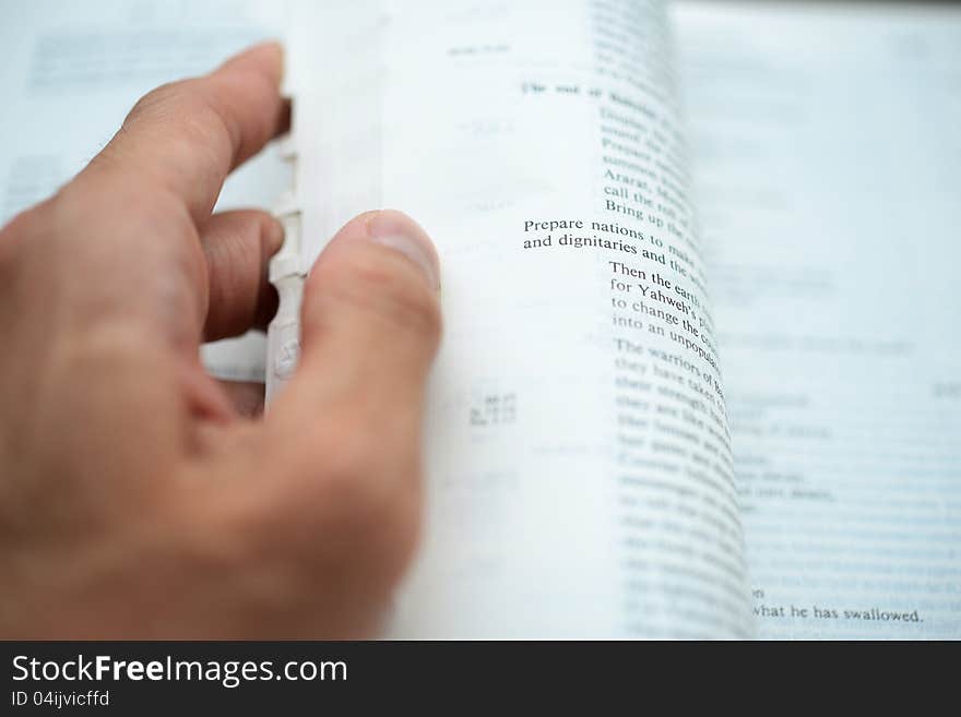 Hand flipping the bible pages with shallow DOF