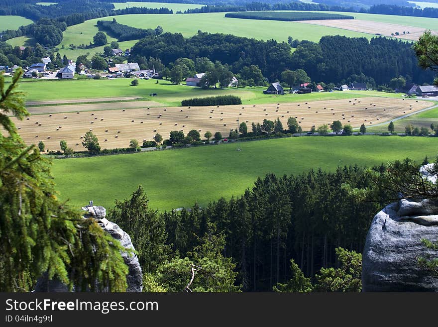 View of farm fields and countryside in the valley, landscape with forests, meadows and rocks. View of farm fields and countryside in the valley, landscape with forests, meadows and rocks