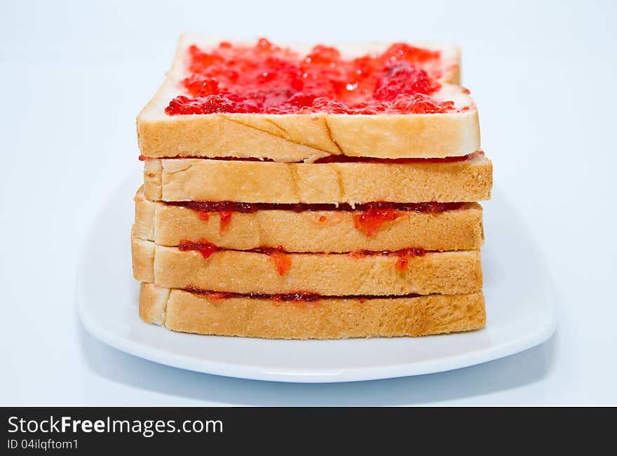 Layer bread with jam in the plate on white background. Layer bread with jam in the plate on white background