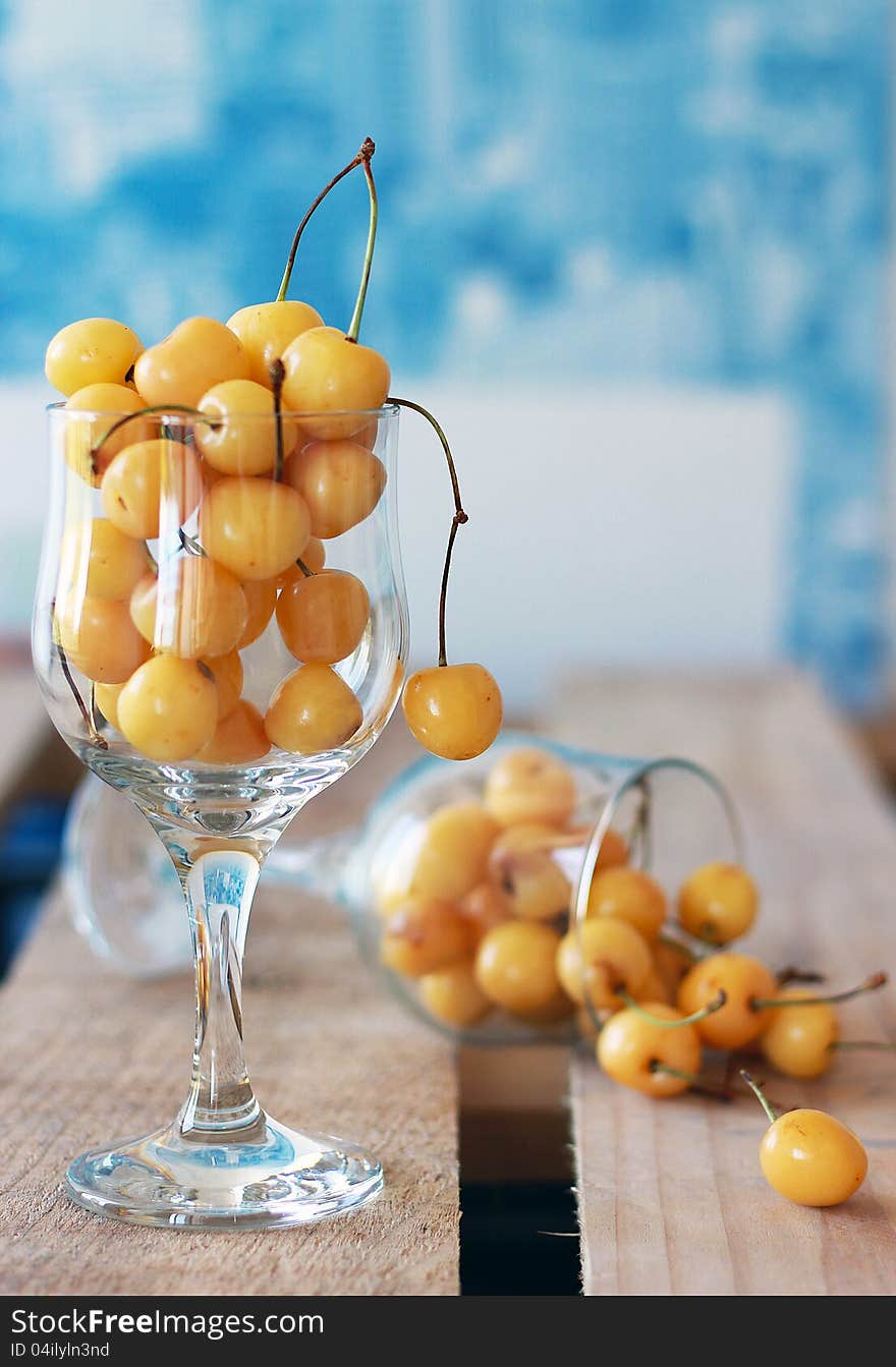 Two cups of white cherries on a blue background. Remind me for summer.