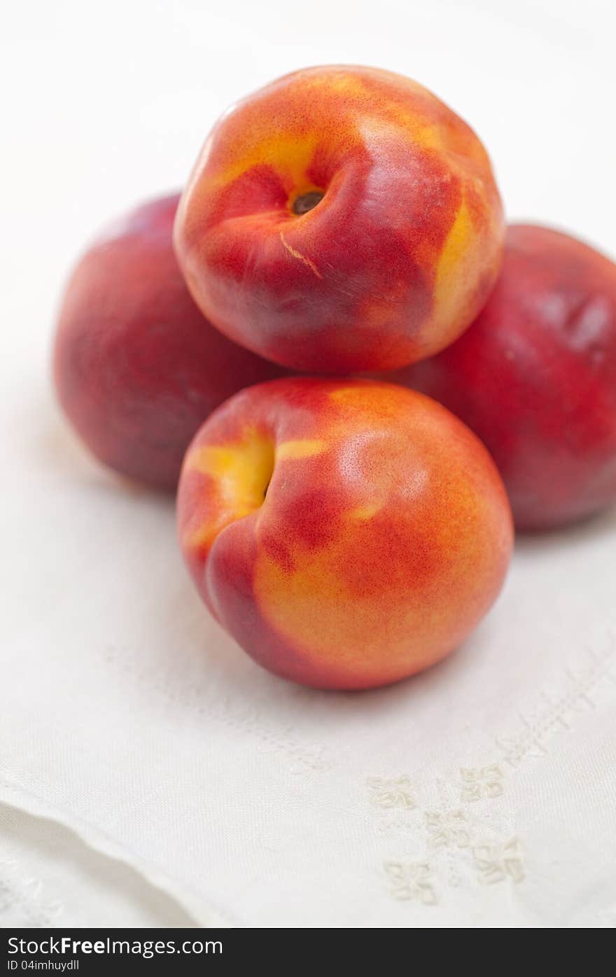 Four Nectarines and Embroidered Napkin