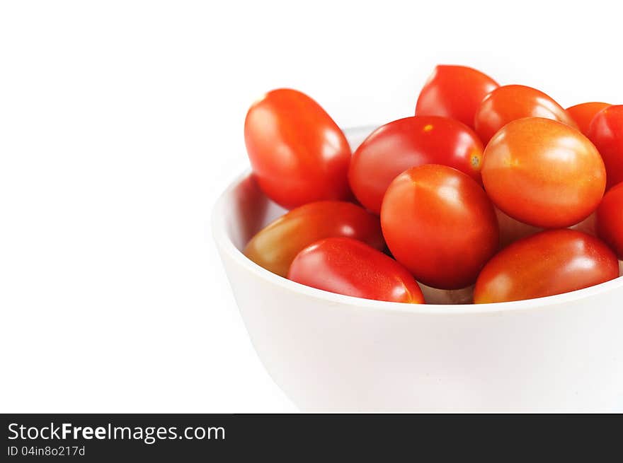 Group of fully ripe organic cherry tomatoes in bright red color arranged in a white melamine bowl on white background. Group of fully ripe organic cherry tomatoes in bright red color arranged in a white melamine bowl on white background