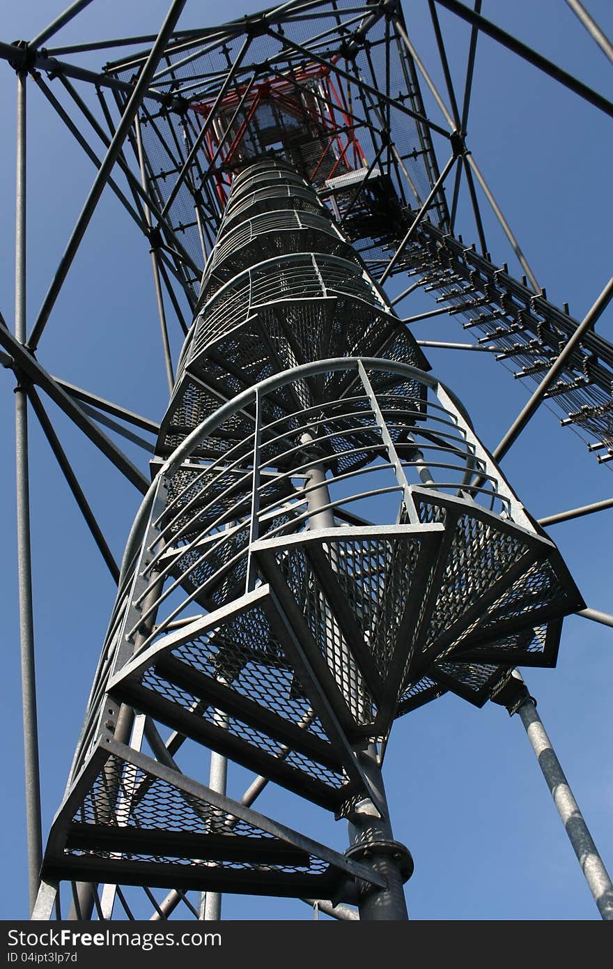 Look at the bottom of a metal structure with a staircase. Look at the bottom of a metal structure with a staircase