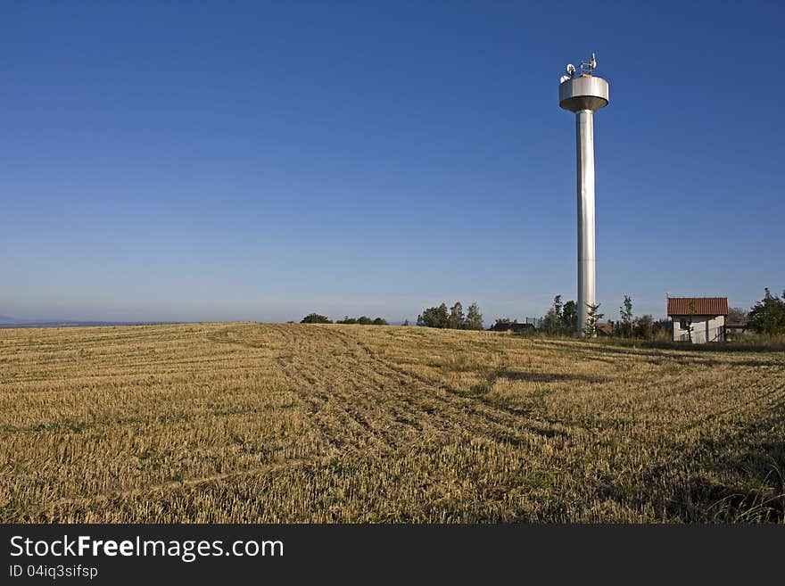 Large white water tower in farm field