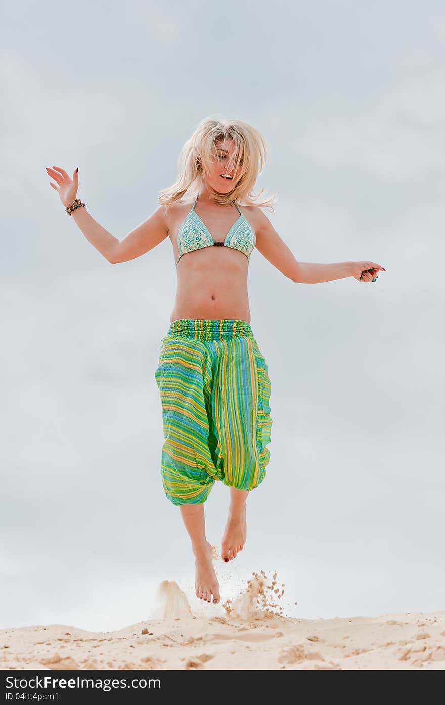 Young girl jumping in the sand