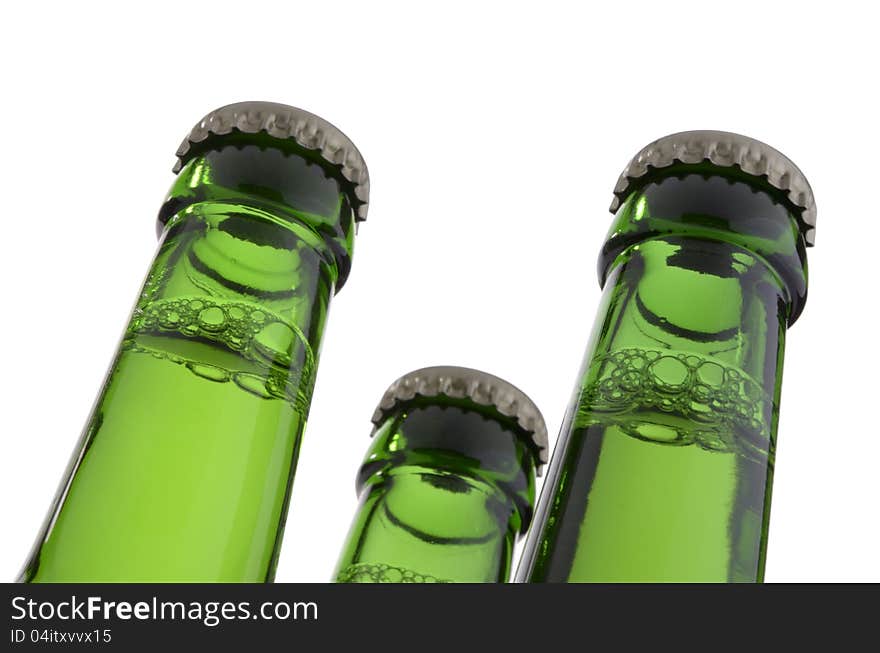 Three green bottle necks with crown caps, containing liquid, isolated on white background