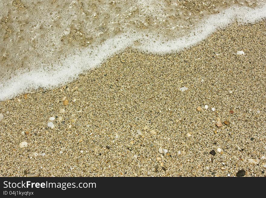 Close up on sand an wave on the beach. Close up on sand an wave on the beach