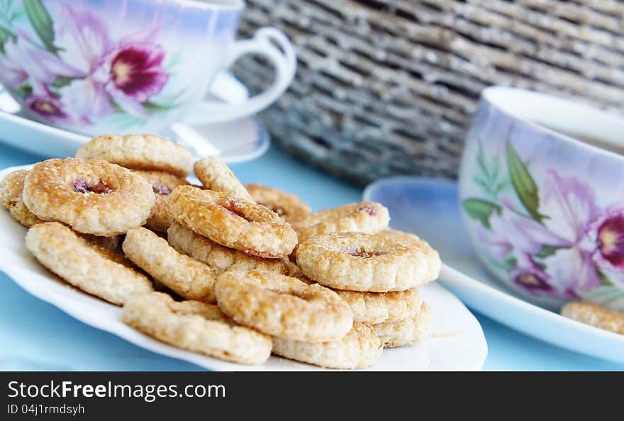 Tea time in the summer garden, tea porcelain cups and biscuits with marmalade