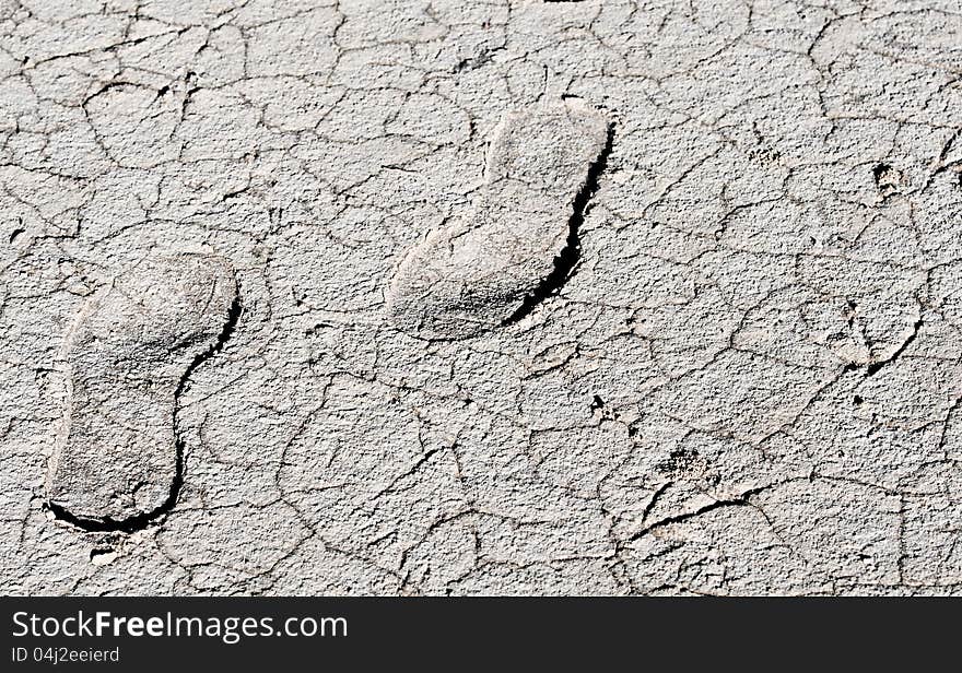 Two Footprints on a dry white cracked land. Two Footprints on a dry white cracked land