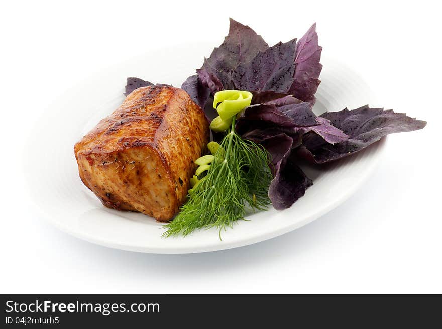 Spicy Roast Pork tenderloin with basil, dill and leek closeup on white background