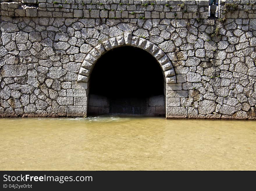 Canal intersection, muddy river and stone walls