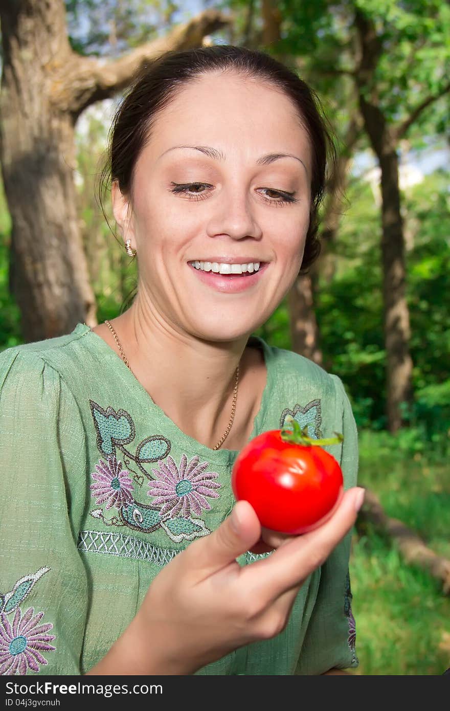 A young woman eating tomato. A young woman eating tomato