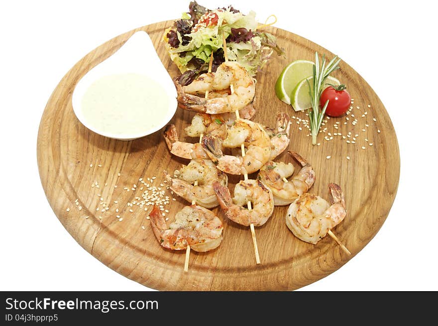 Grilled shrimp with a salad on a wooden plate