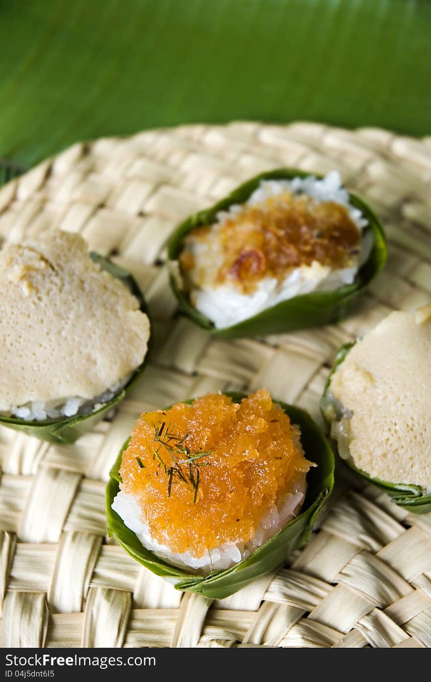 Thai native dessert. Sweet sticky rice with topping in banana leaf cup.