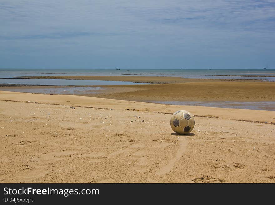 Old soccer leather ball on sandy beach. Old soccer leather ball on sandy beach