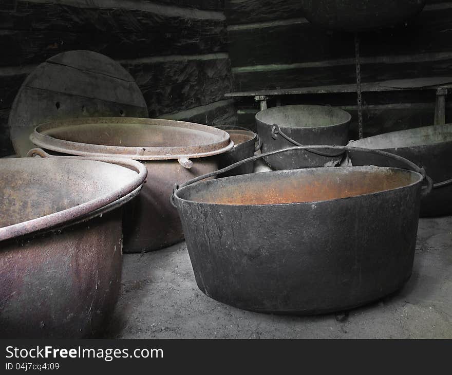 Group of old rusty large iron kettles.