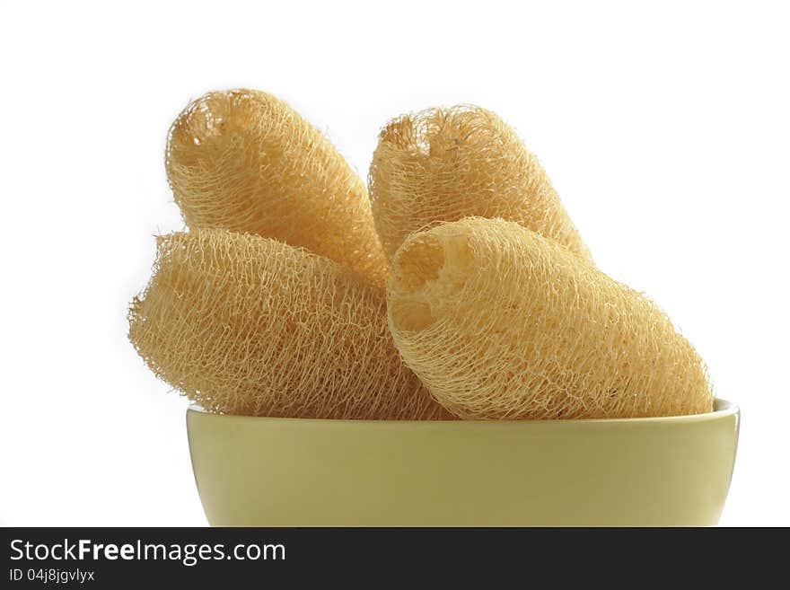 Loofah sponges with cup on white background