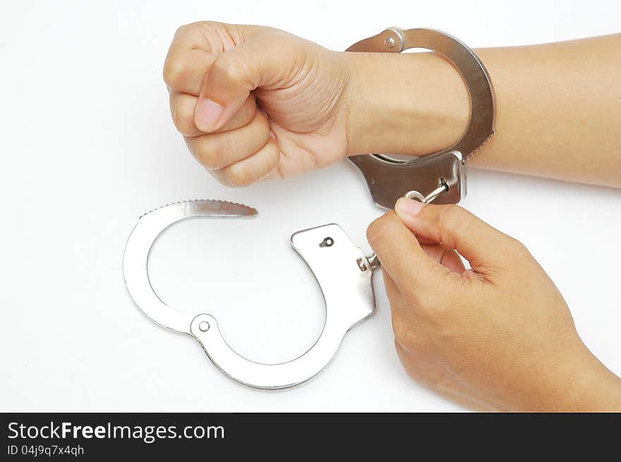 Another hand try to open a handcuffs. Another hand try to open a handcuffs