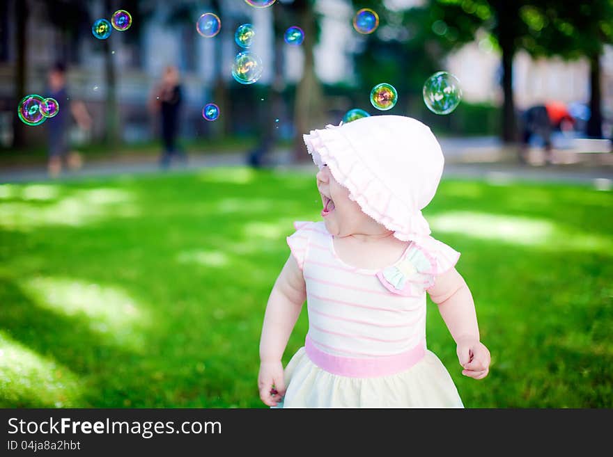 Little girl playing with soap bubbles outdoors. Little girl playing with soap bubbles outdoors